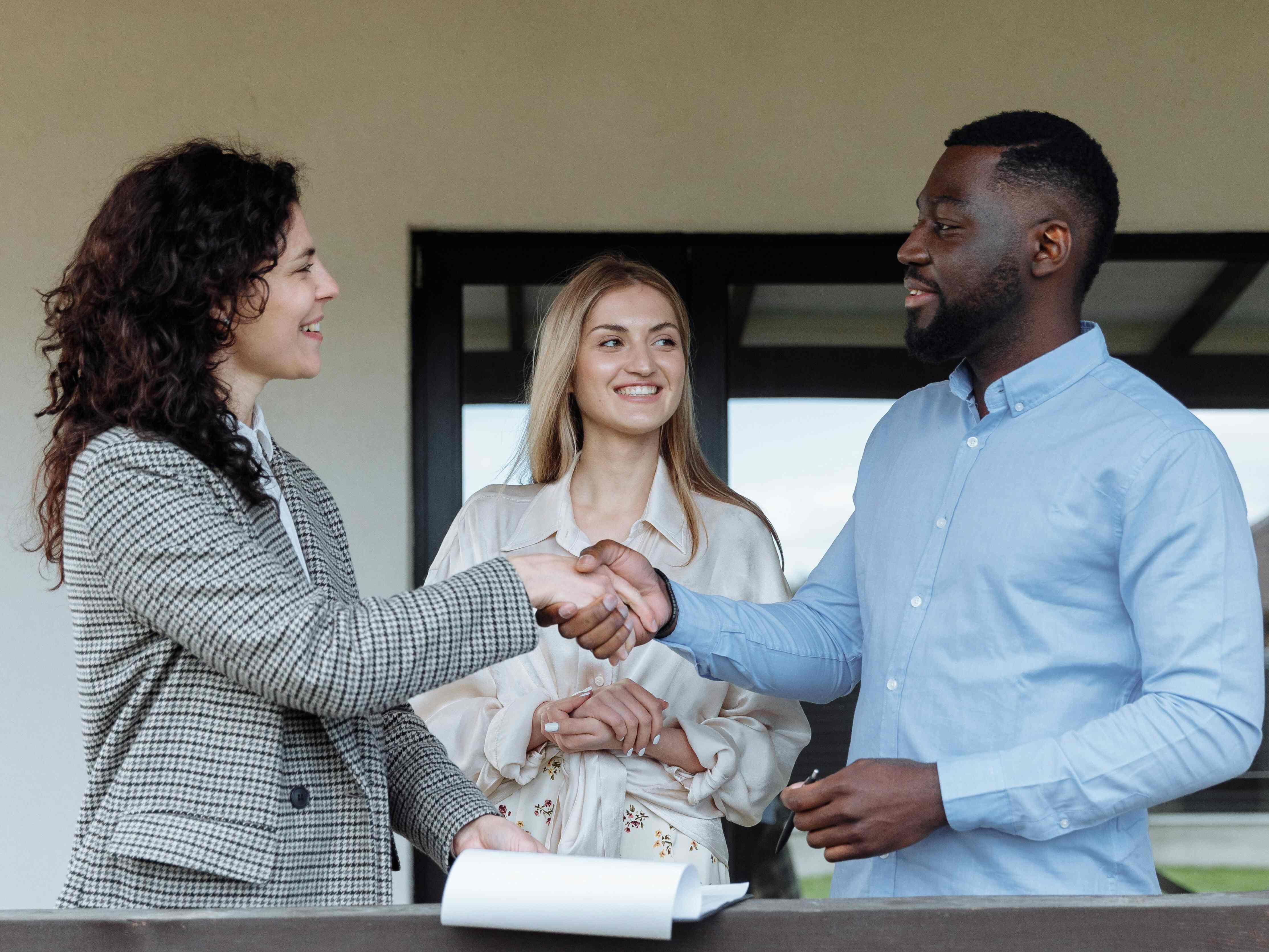 Real estate agent shaking hands with happy clients